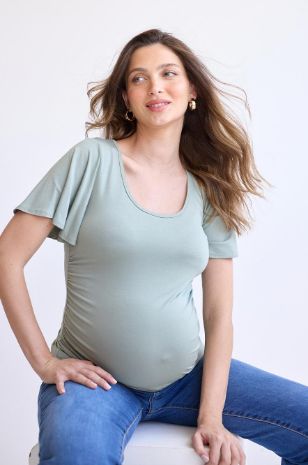 אישה לובשת 	חולצת הריון בילי זית בהיר