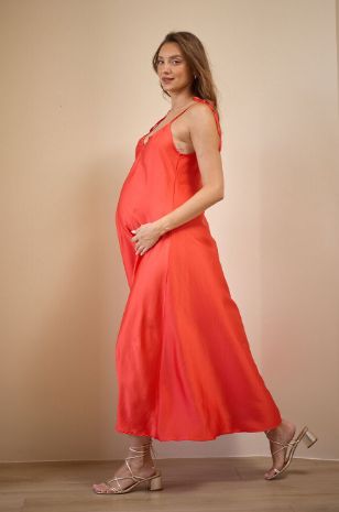 אישה לובשת שמלת הילה להריון אדומה